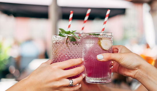 Three people with beverage in hand clinking glasses together